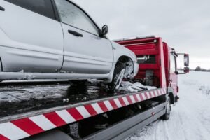 car on tow truck on snow road